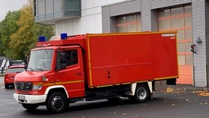 Der rote Lastkraftwagen steht vor einem Feuerwehrhaus