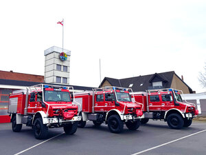 drei rote Tanklöschfahrzeuge stehen nebeneinader vor dem Feuerwehrhaus