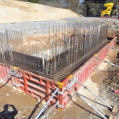 Bild vergr&ouml;&szlig;ern: In einer Baugrube befindet sich eine kniehohe Schalung, die von Metallstreben gestützt wirde. Aus dem umschalten Bereich ragen Metallstreben hervor.