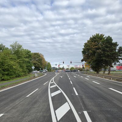 Bild vergr&ouml;&szlig;ern: Vor der Kreuzung mit Ampelanlage erstreckt sich die sanierte Straße mit vier Fahrbahnen und neuer Fahrbahnmarkierung