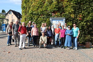 Die Wandergruppe posiert gemeinsam vor einer mit Eufe bewachsenen Wand für das Foto